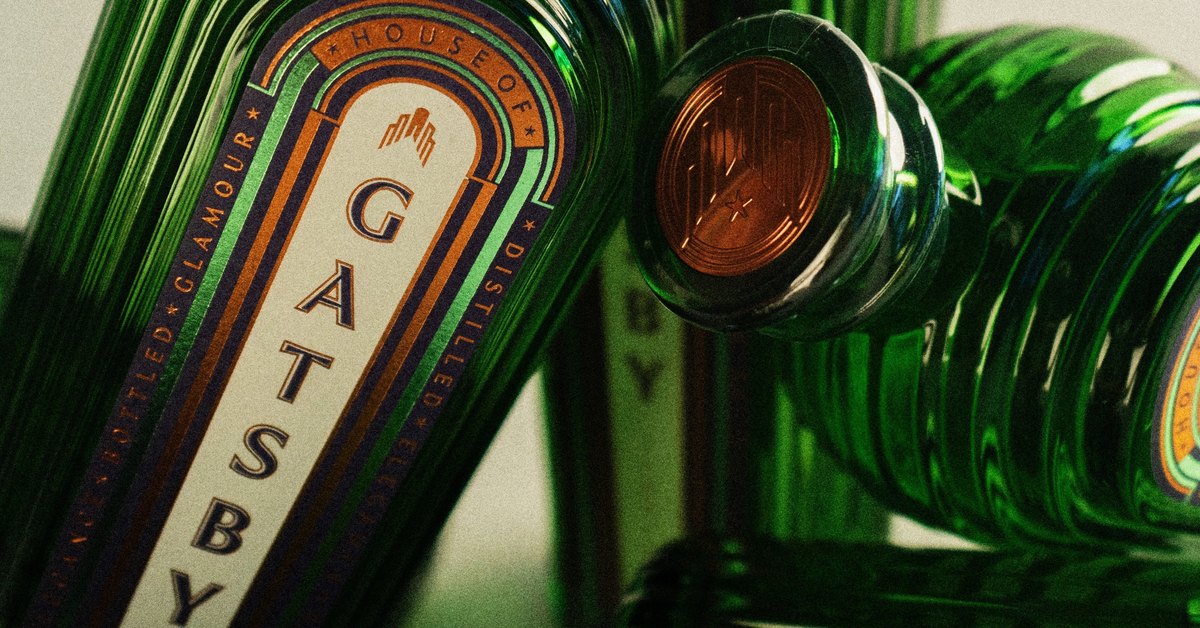 Bottles of Gatsby Gin in emerald fluted glass, one label showing the Gatsby name and a copper-capped stopper beside it.