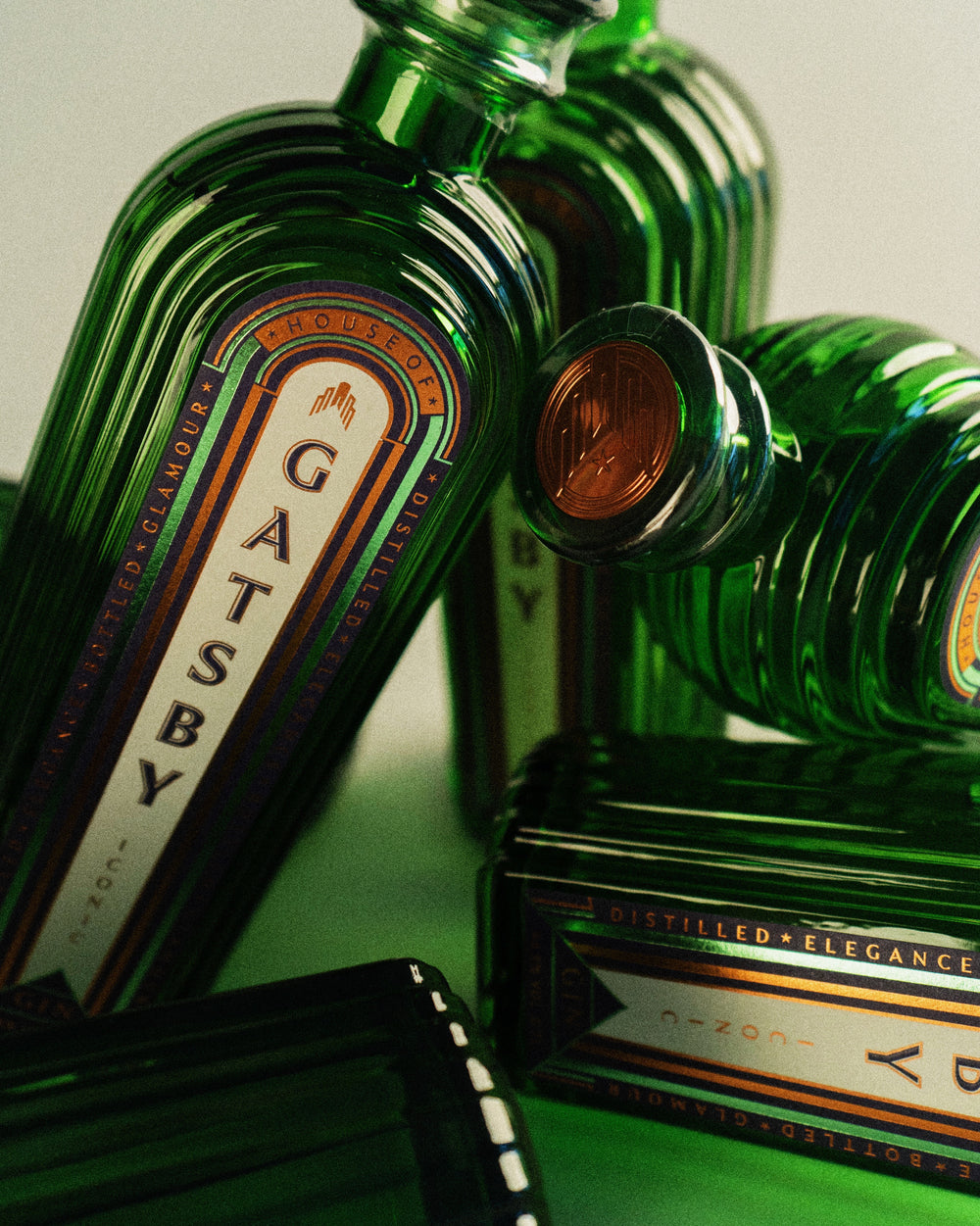 A close cluster of Gatsby Gin bottles, showing the fluted glass and the faceted stopper